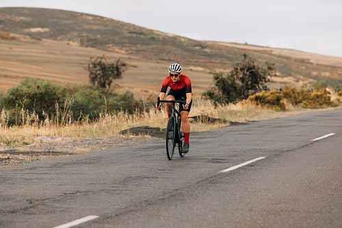 Young woman riding a bike on countryside road