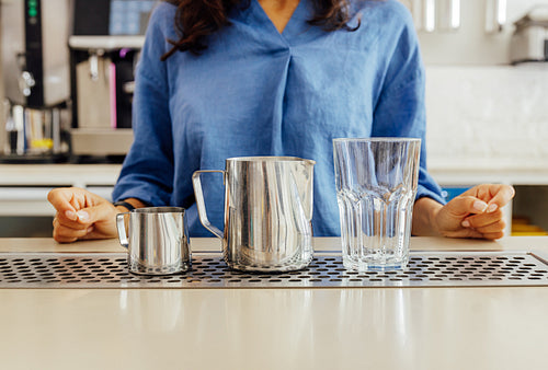 Shot of an unrecognizable female barista preparing for making latte