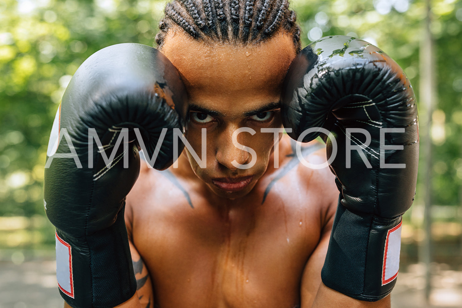 Close up portrait of a sweated kickboxer with gloves and mouth guard looking at the camera	