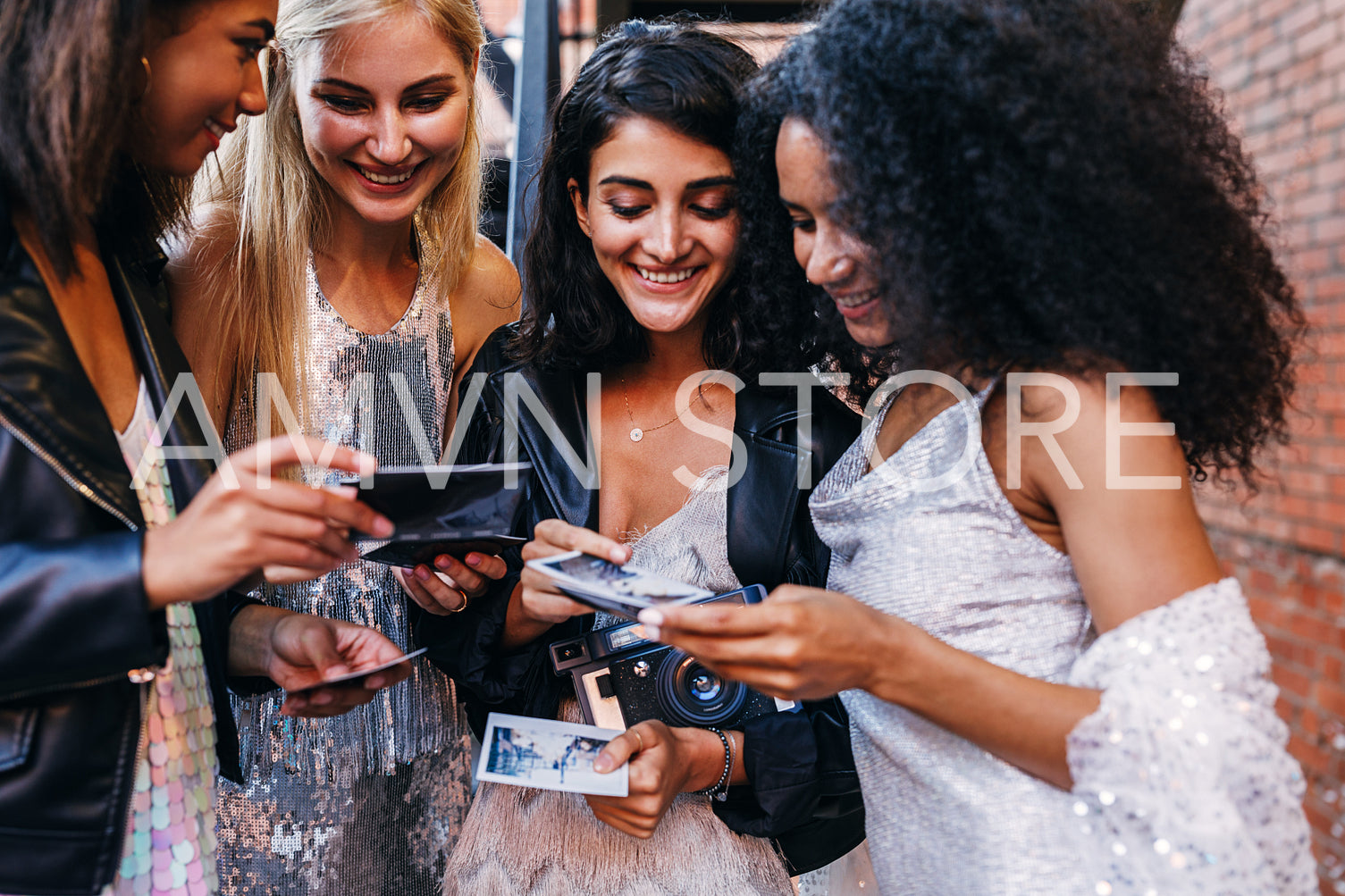 Women with instant photographs. Friends choosing frames after party.	