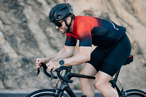 Cyclist doing intense ride outdoors. Professional male road bike rider training outdoors.