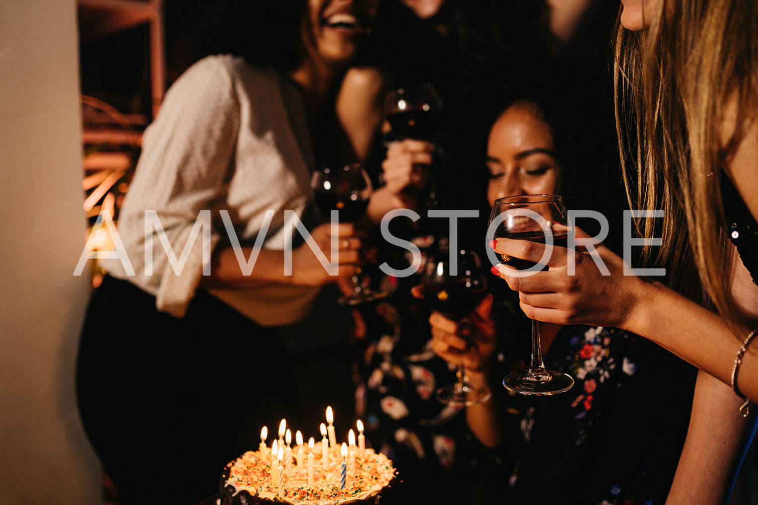 Group of four female friends celebrating birthday at home, having fun	