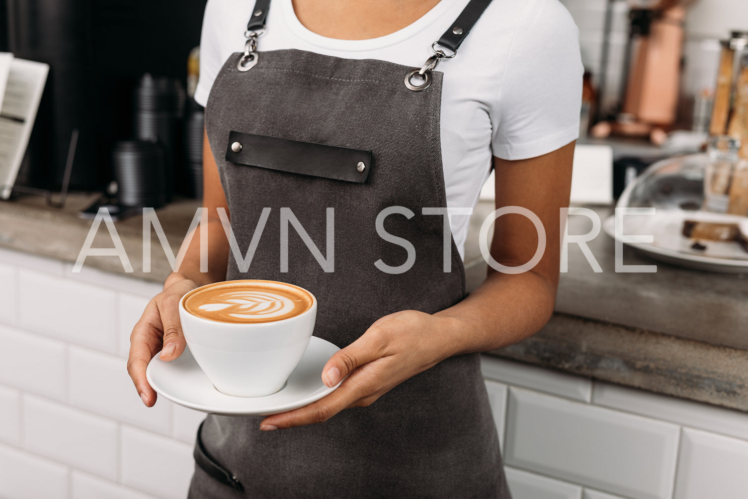 Cropped shot of an unrecognizable barista holding a cup of coffee. Waitress in an apron with a freshly prepared cappuccino.