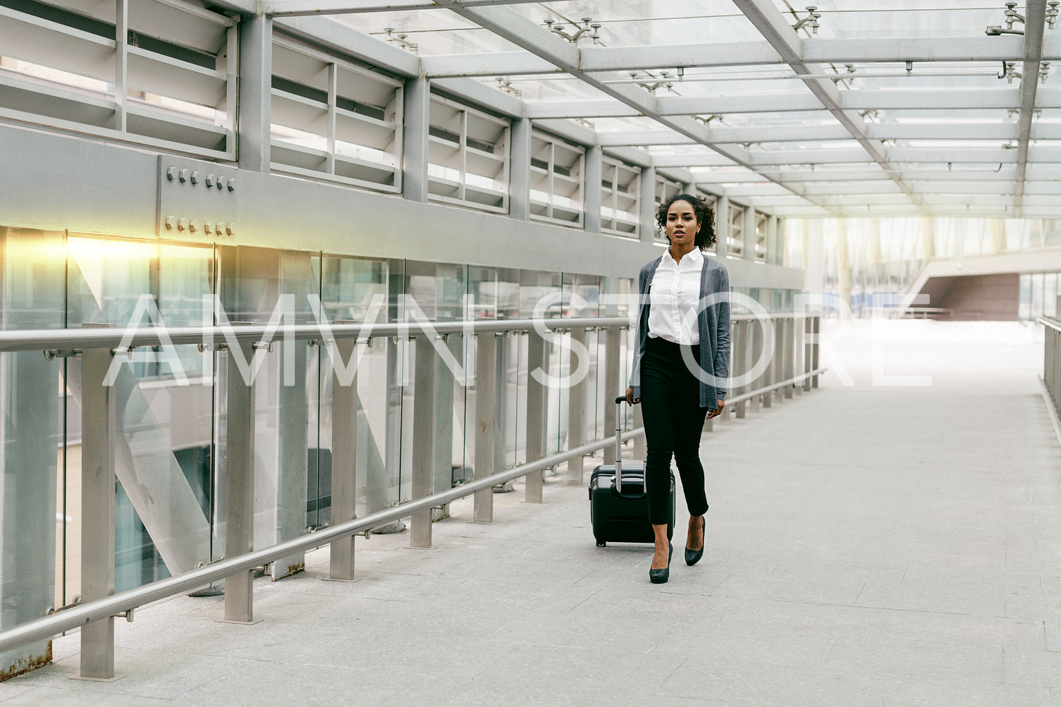 Young woman with luggage walking on terminal, preparing for business trip	