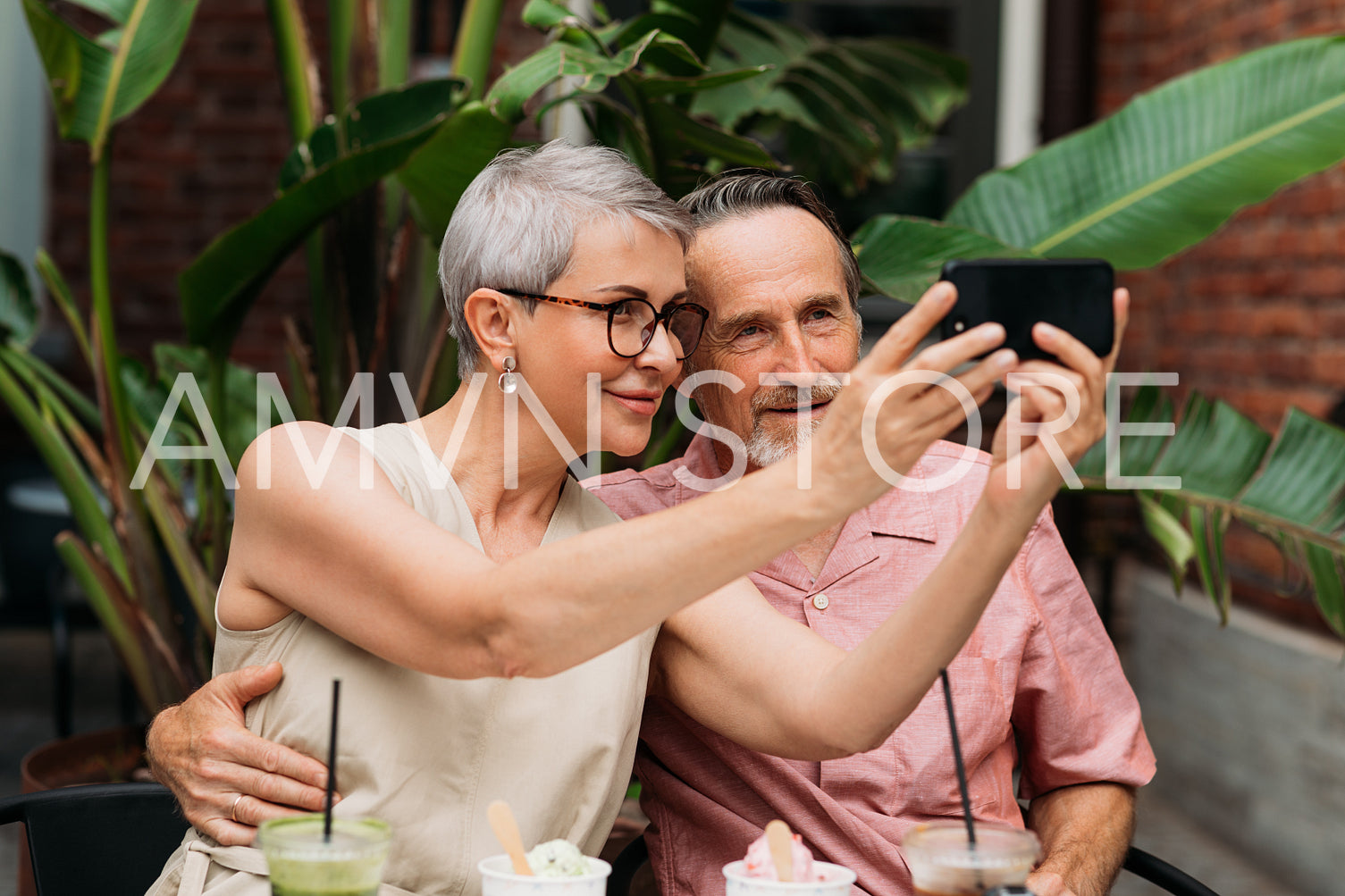 Senior couple taking a selfie while sitting together at an outdoor cafe