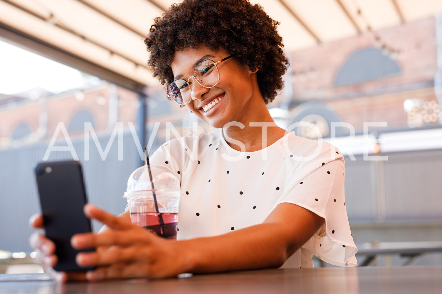 Happy girl posting new content in social media. Beautiful woman chatting from outdoor cafe.	