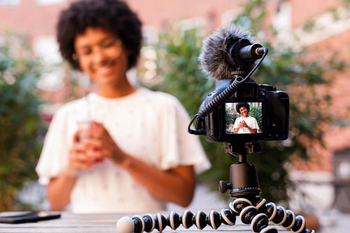 Woman recording a video content while sitting in outdoor cafe