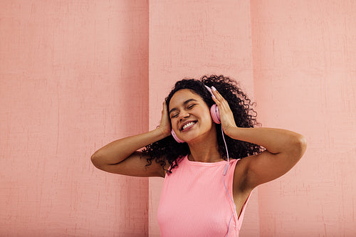 Portrait of a happy woman with closed eyes listening to music we