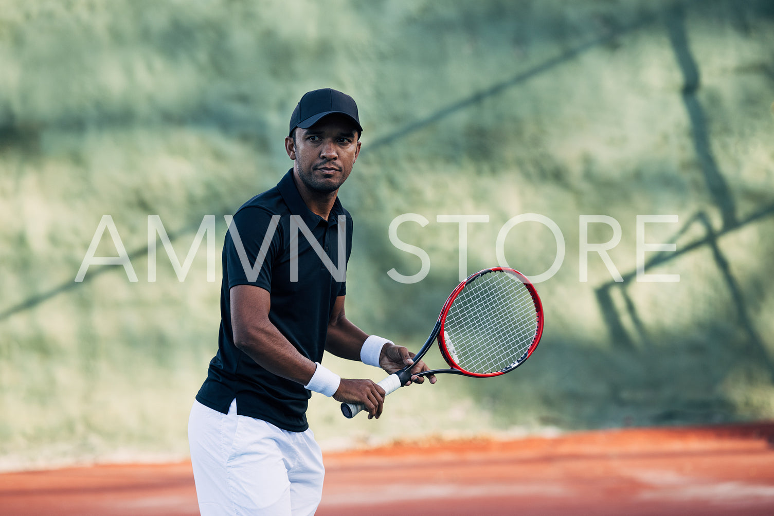 Professional tennis player with racket looking at camera on hard court