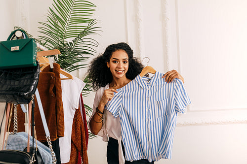 Young woman holding a hanger with a shirt