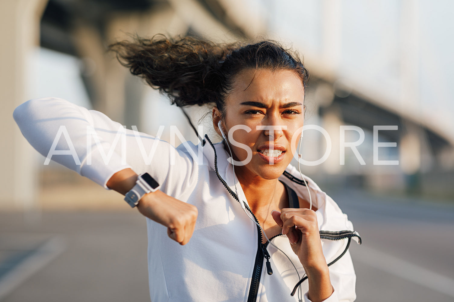 Strong young woman practicing boxing outdoors. Female boxer doing punches.	