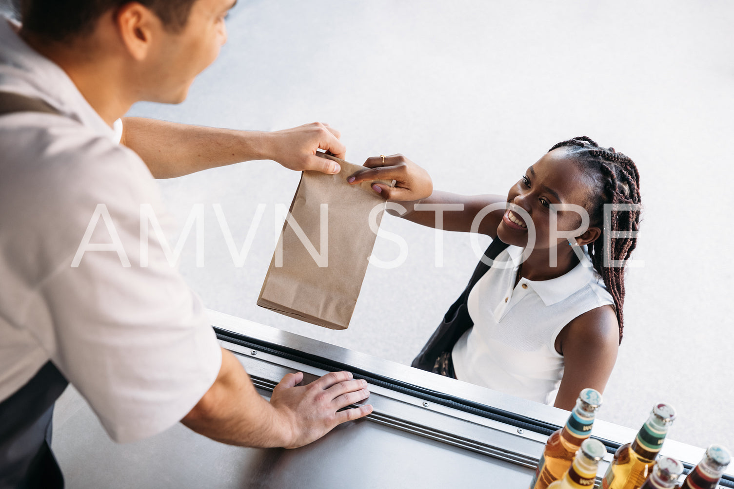 Woman receiving meal from a food truck in city. Young smiling female buying takeaway food.