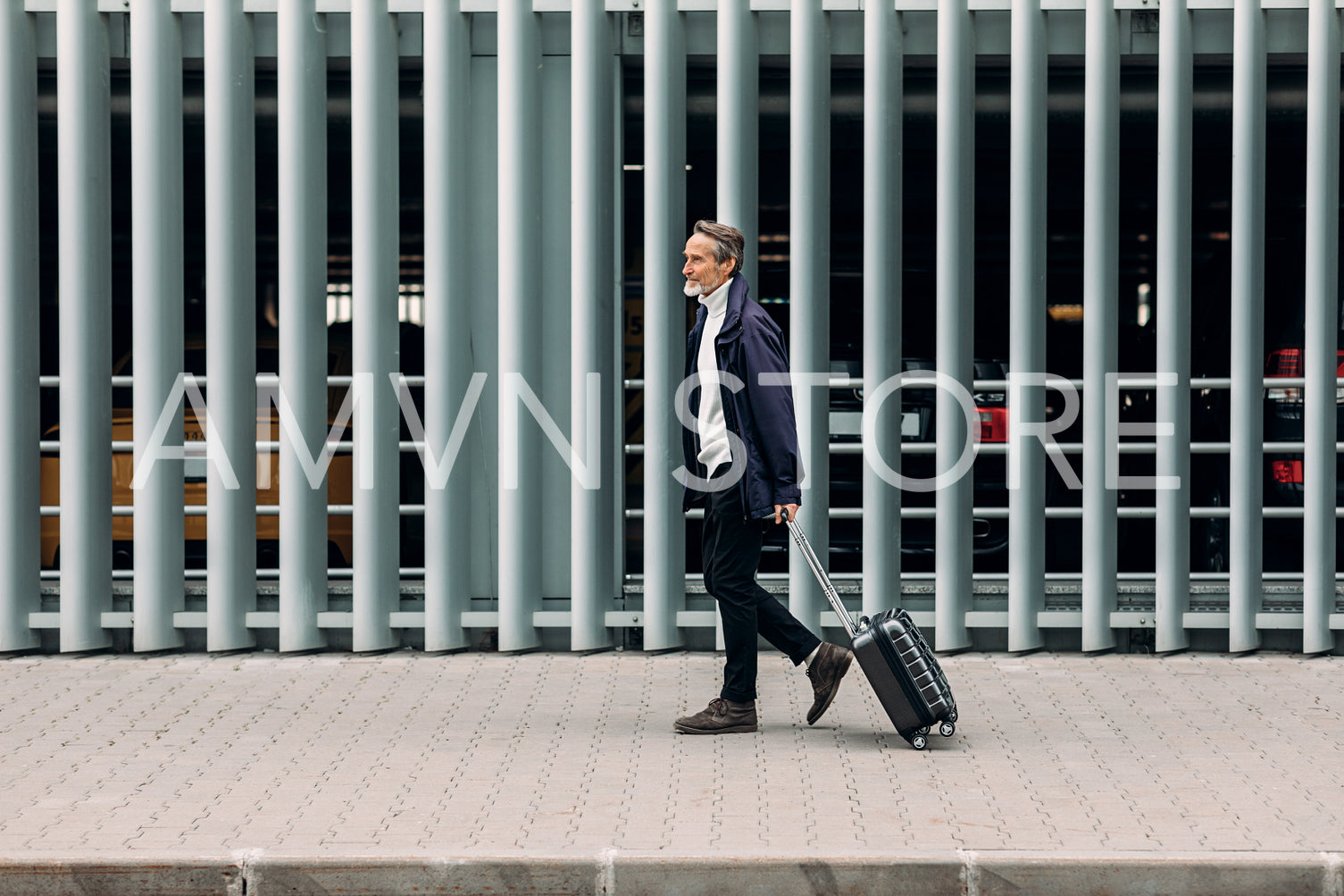 Side view of a man tourist walking with suitcase near a parking	