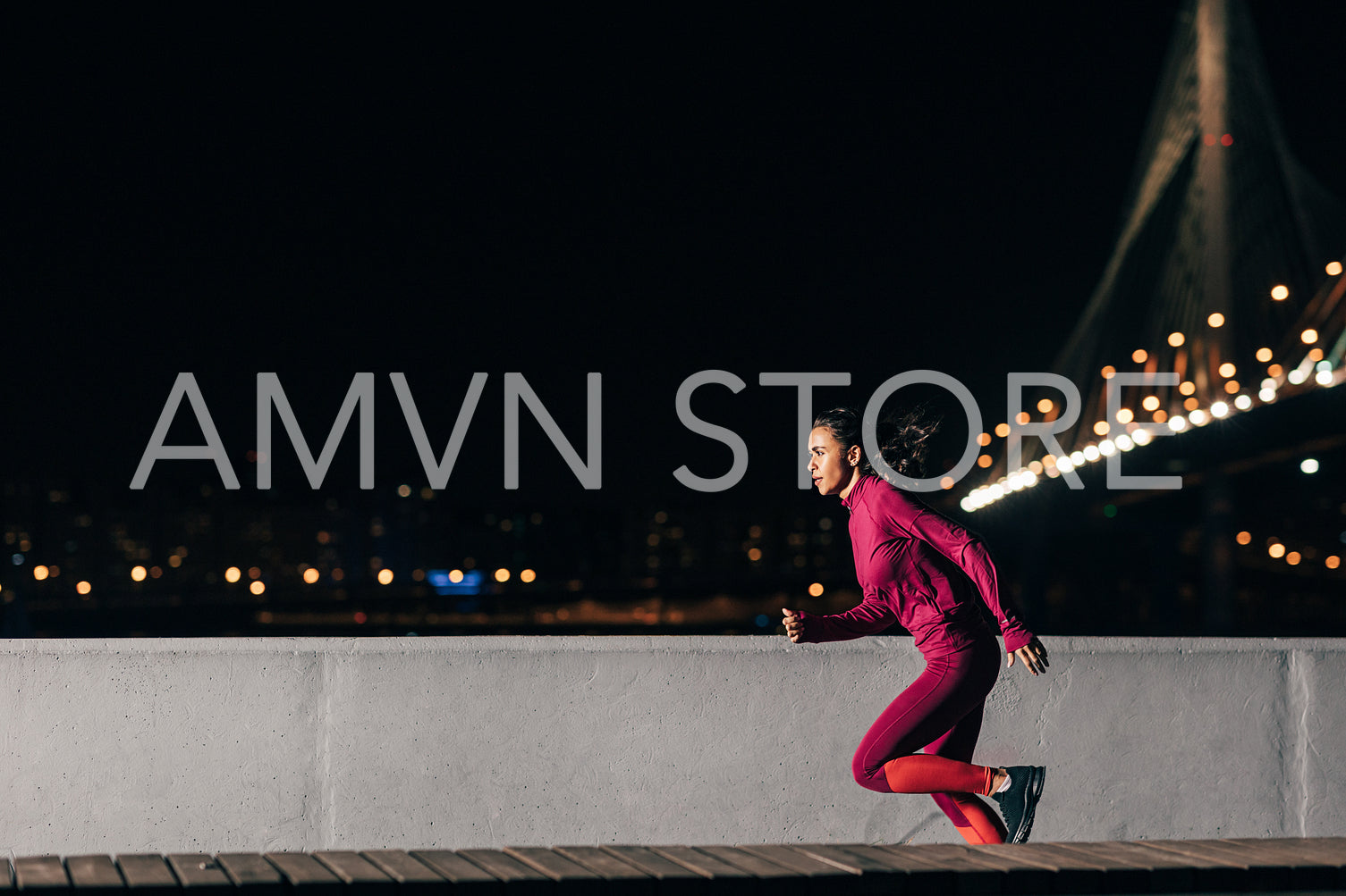 Woman runner at night. Sportswoman sprinting outdoors against a bridge.