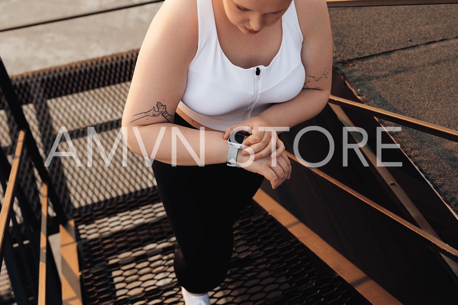 Unrecognizable curvy woman checking activity tracker while stepping up on staircase outdoors	