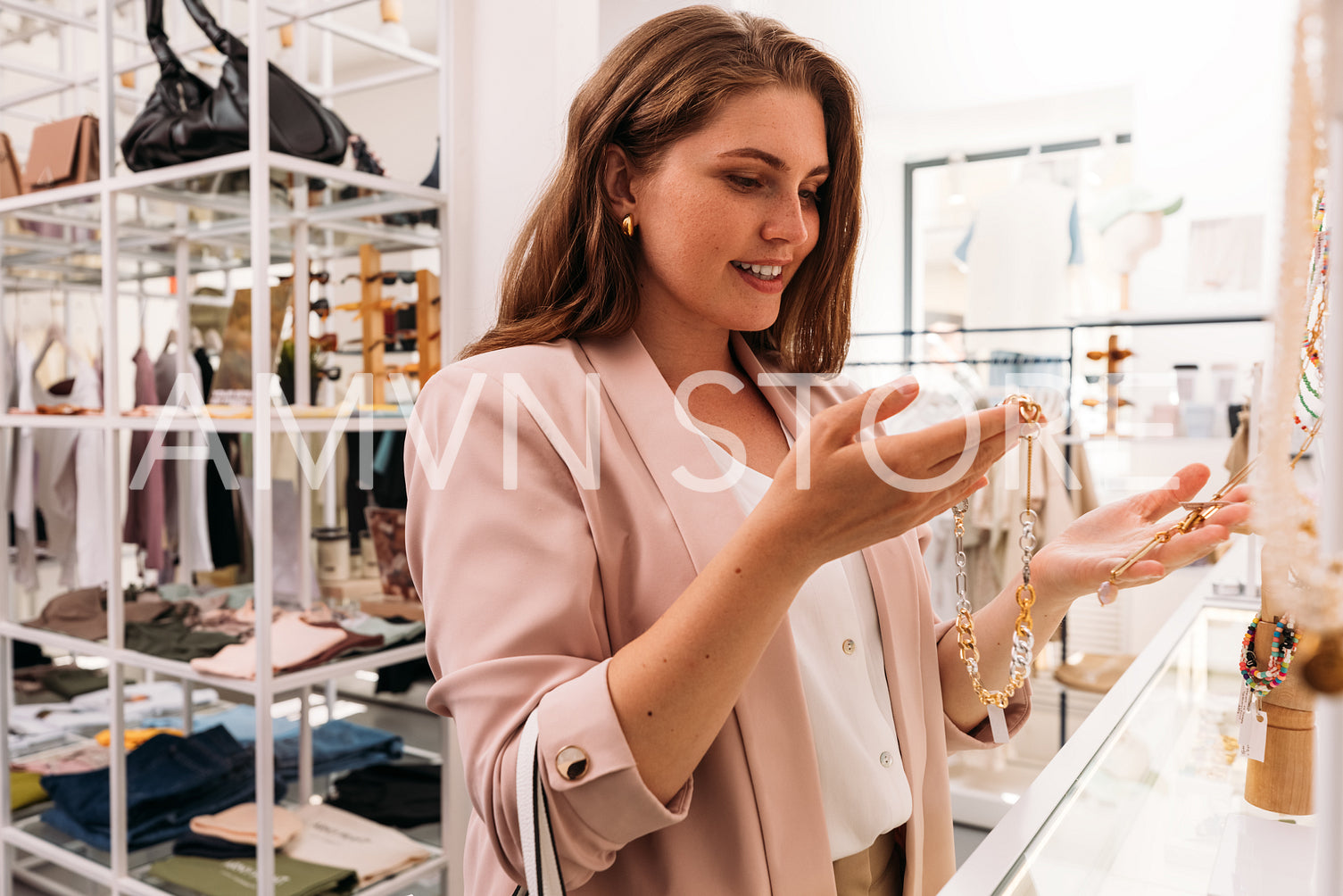 Cheerful woman standing at counter in a fashion store and choosi