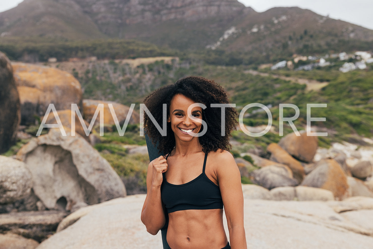 Portrait of a young beautiful woman with mat standing in park and smiling