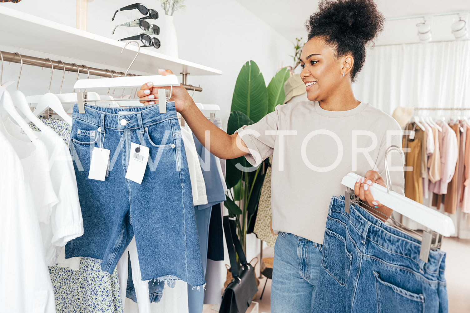 Saleswoman arranging clothes in a rack in her small boutique