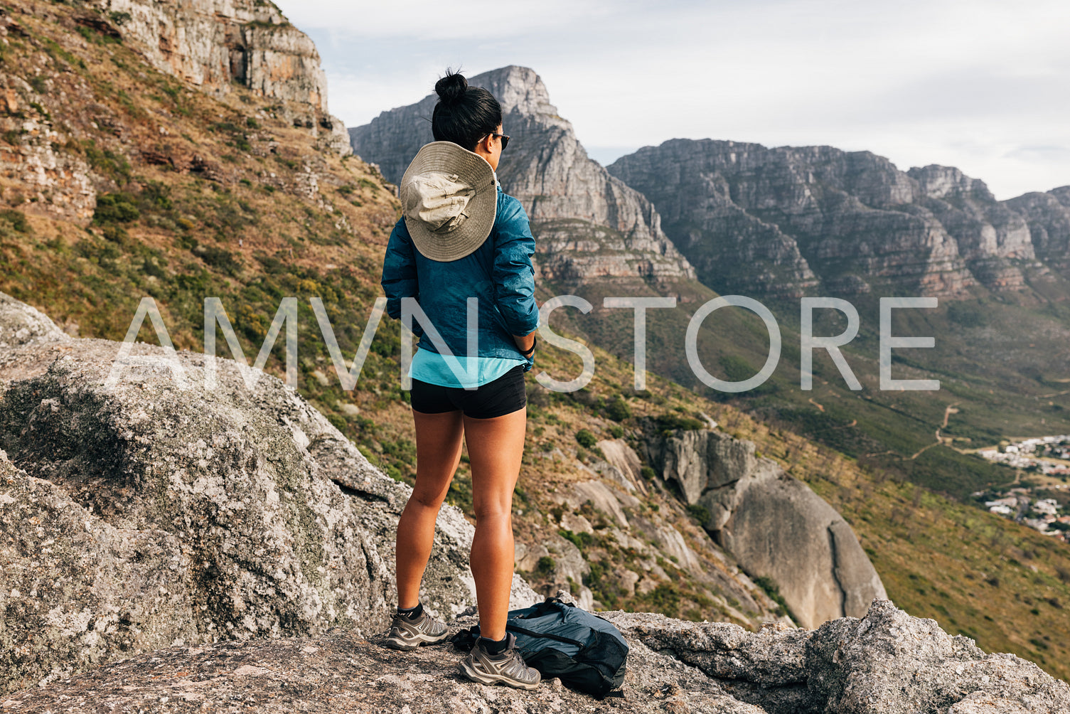 Back view of woman hiker looking at the view from a mountain top