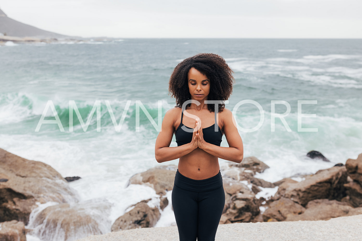 Female practicing yoga on the shore. Young woman meditating with closed eyes.