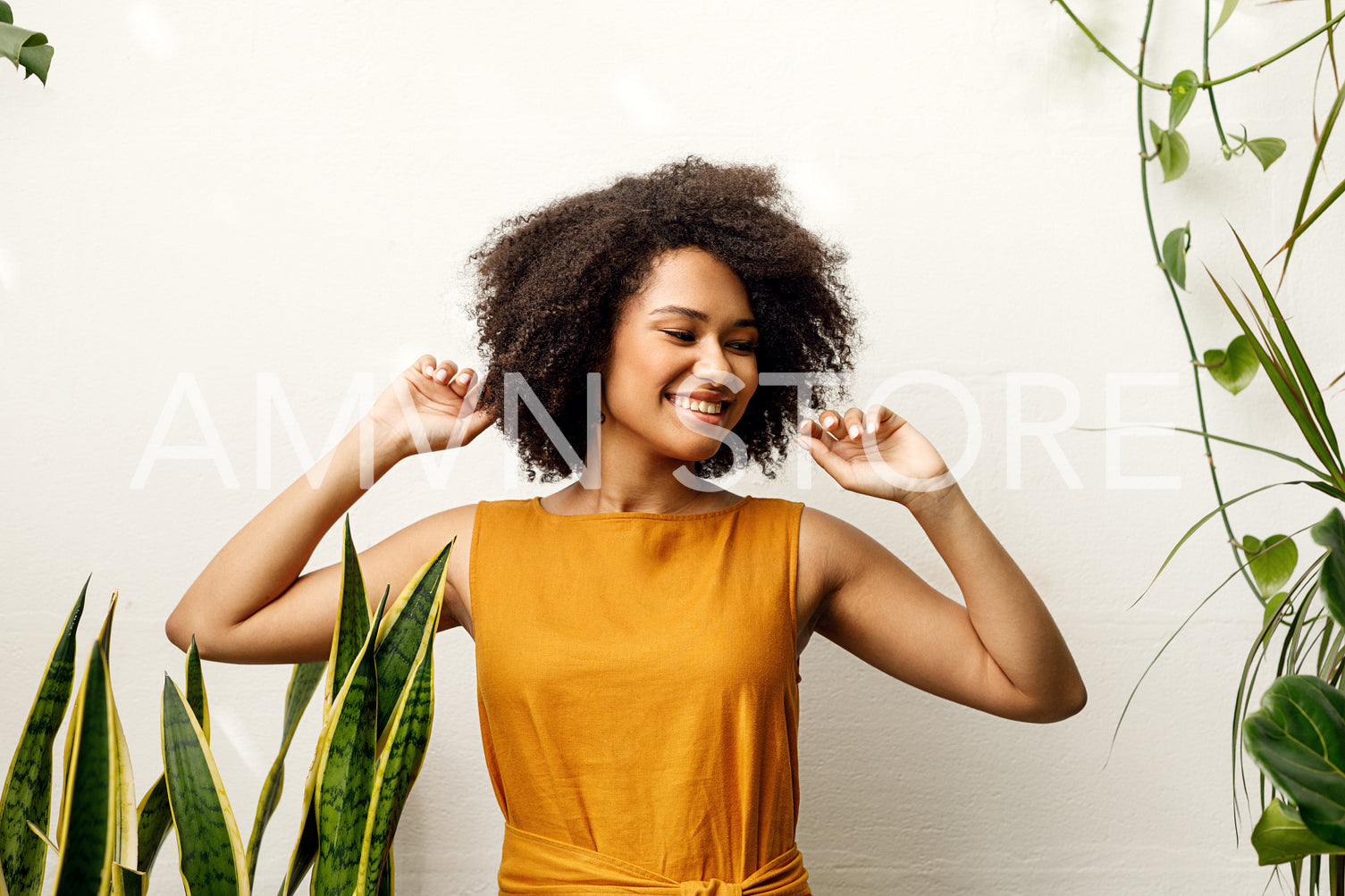 Happy woman posing in her floral shop at wall	