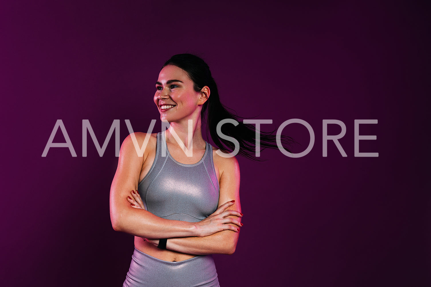 Happy woman athlete with crossed arms against a magenta background