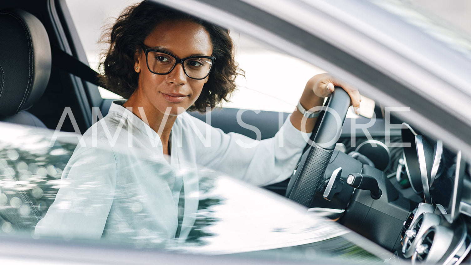 Young female entrepreneur driving a car looking away	