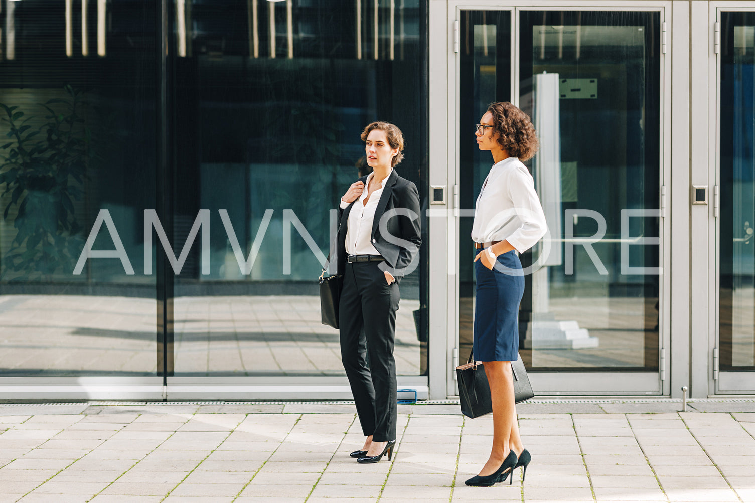 Two women colleagues standing at the office building outside	