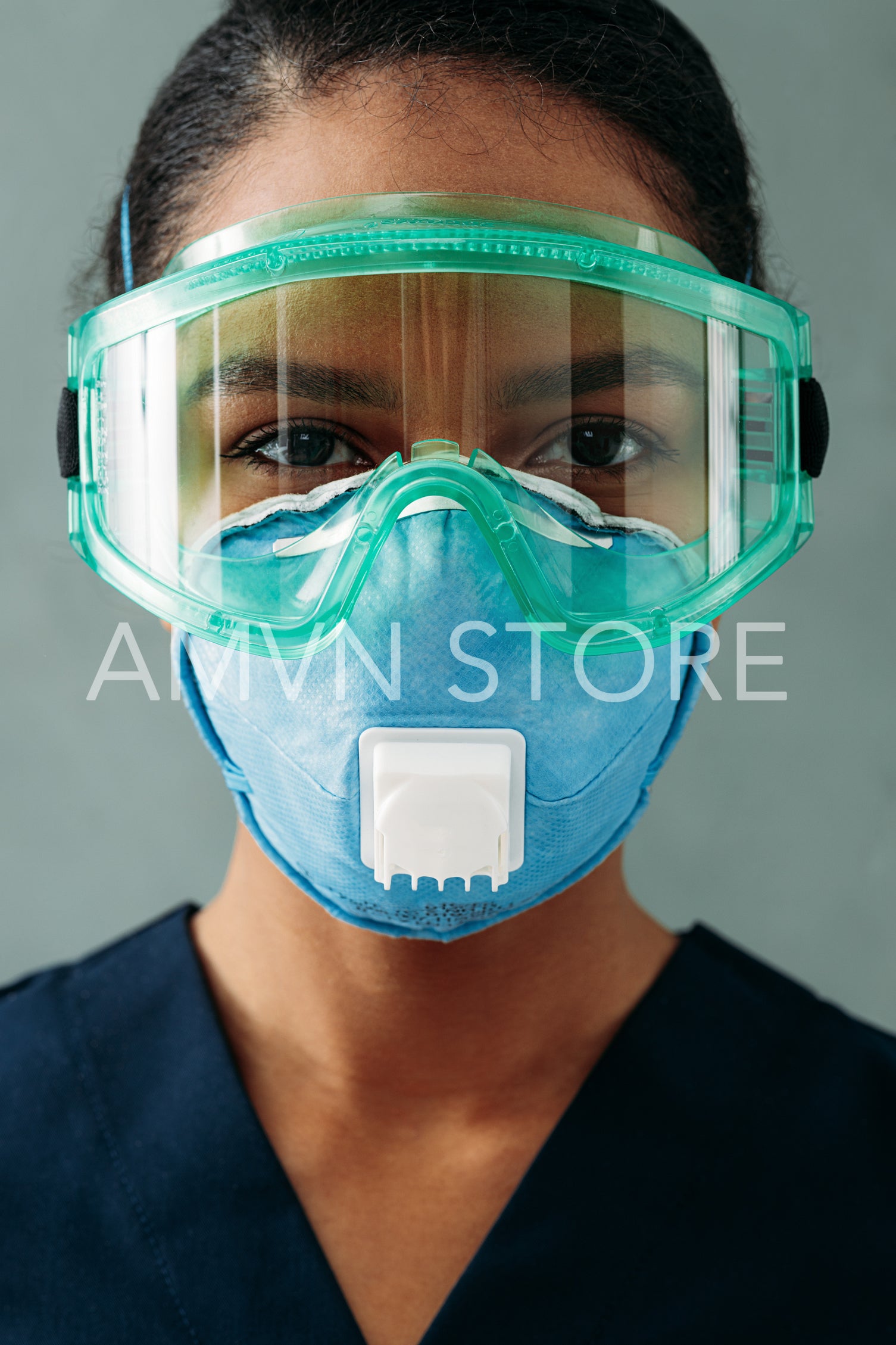 Close up portrait of a medical specialist in respirator and protective eyeglasses looking straight of a camera	