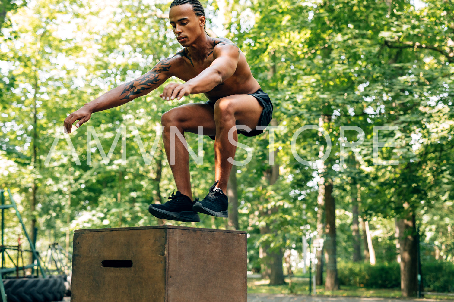 Young athletic male doing box jump on sports ground	