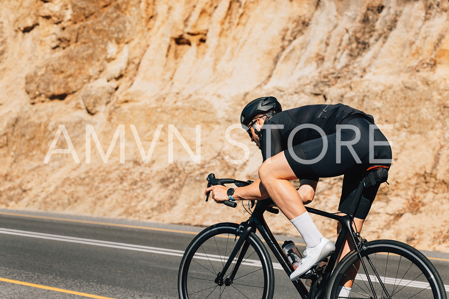 Male cyclist on his road bike. Professional bicycle rider practicing at sunny day.