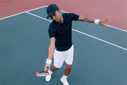 High angle of a professional tennis player practicing on a hard court