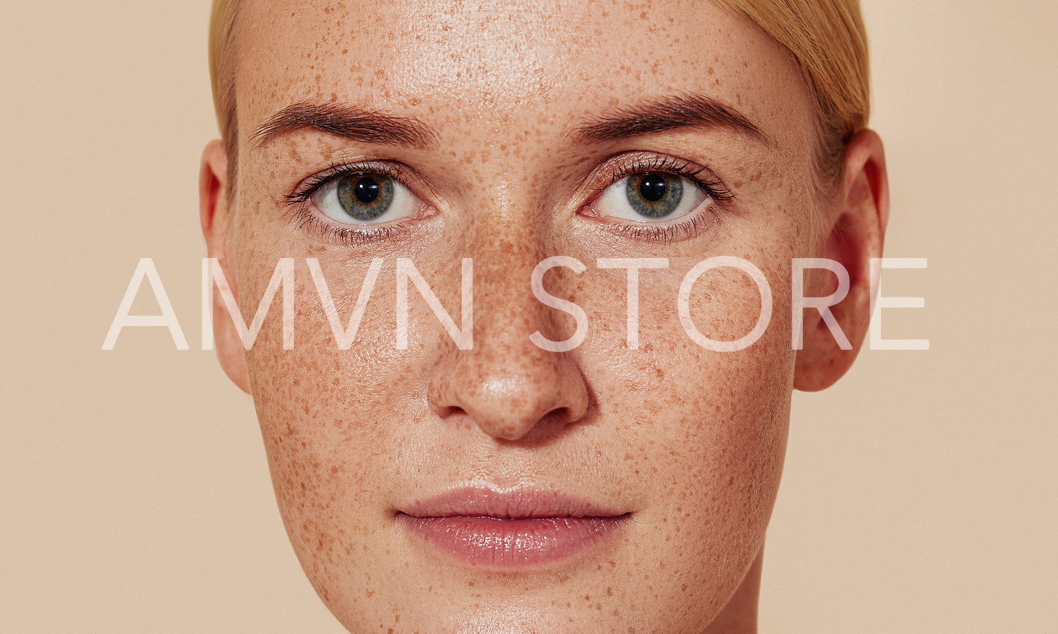 Close-up studio shot of a young female with freckles. Portrait of natural beauty woman with smooth skin against pastel backdrop.