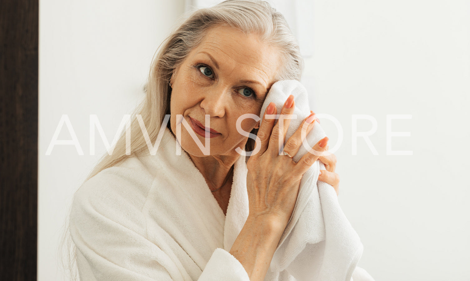 Woman with grey hair wiping her face