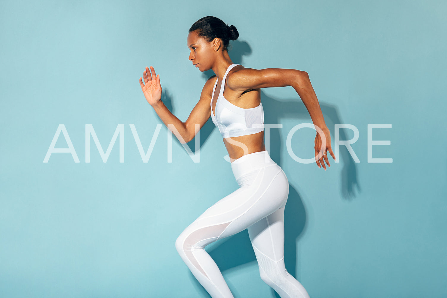 Side view of healthy young woman running at blue background	