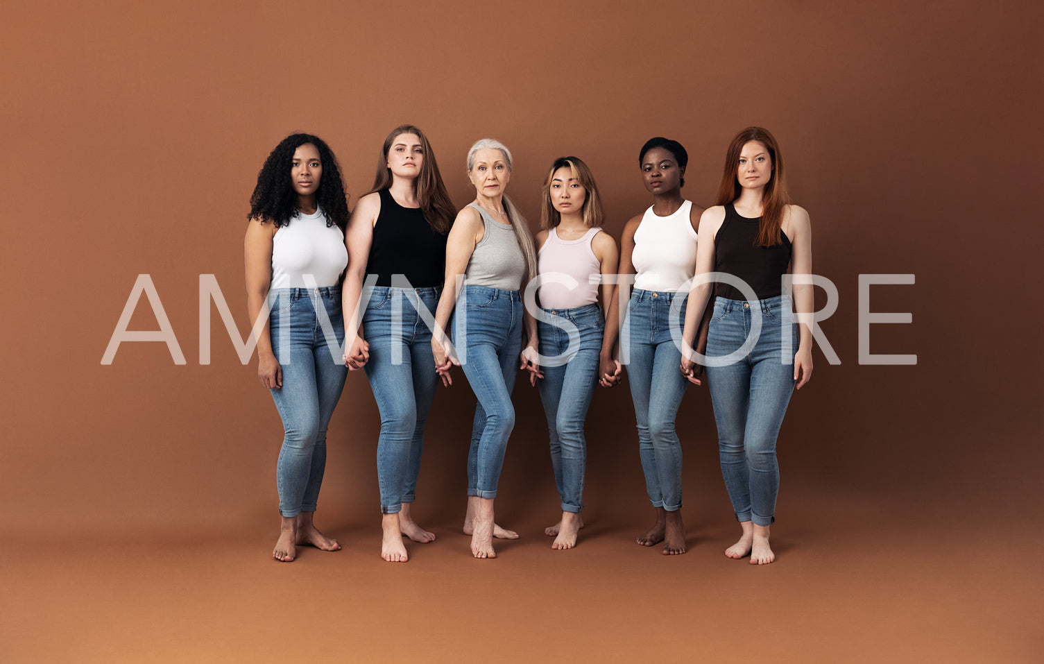 Six serious women standing together holding hands in studio