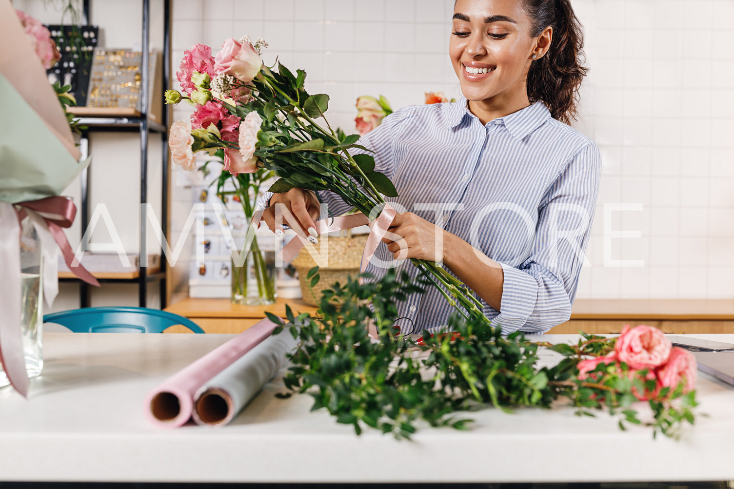 Smiling flower shop owner creating a bouquet at counter	