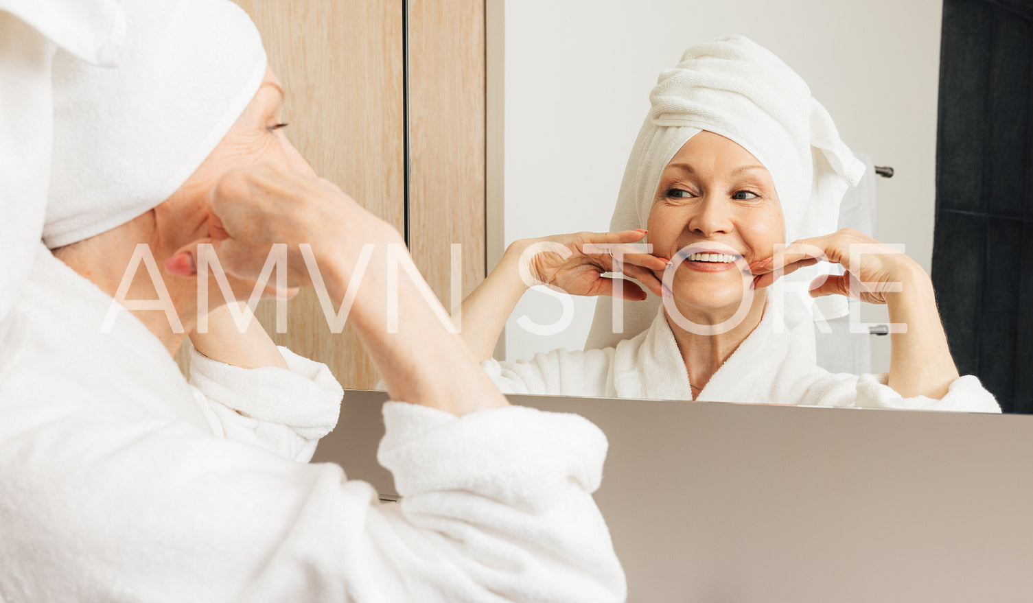 Senior female with a towel wrapped around her head enjoying her morning routine in the bathroom