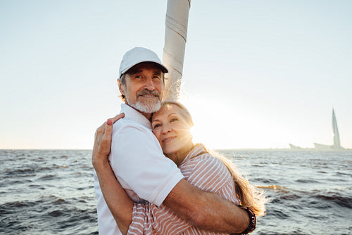 Senior man and woman embracing outdoors. Mature couple enjoying sunset.