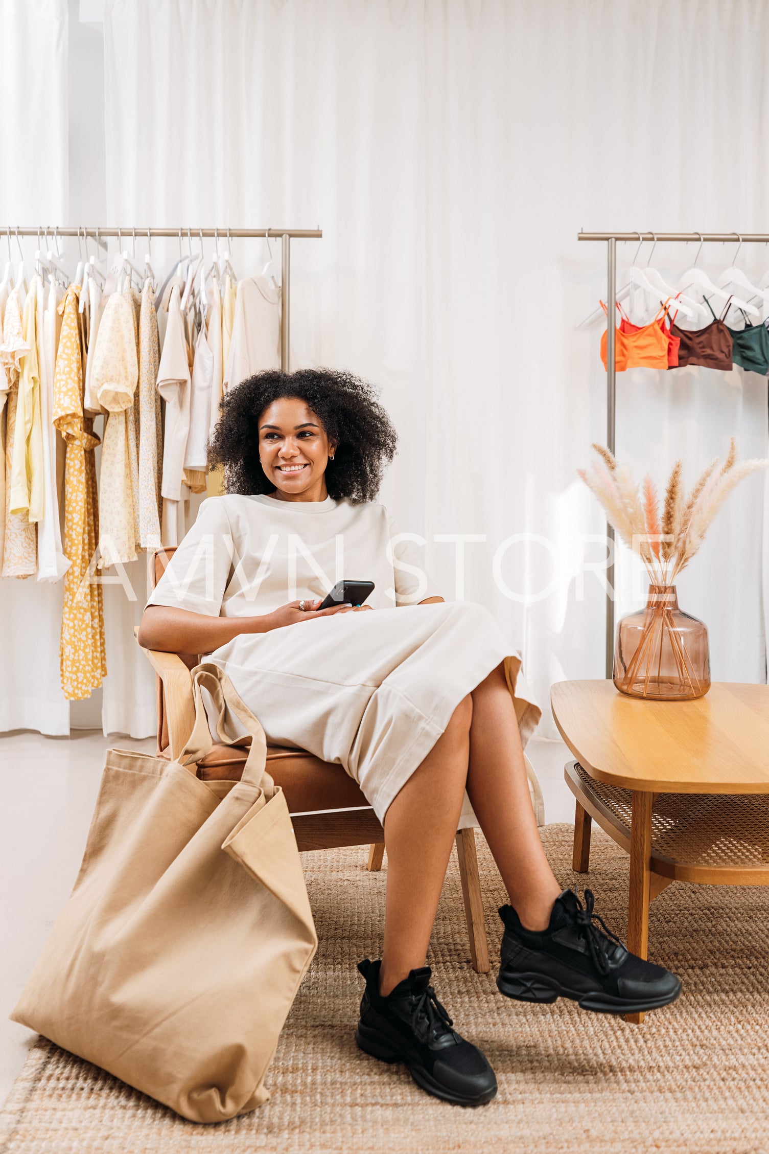 Cheerful female buyer relaxing during shopping in fashion store