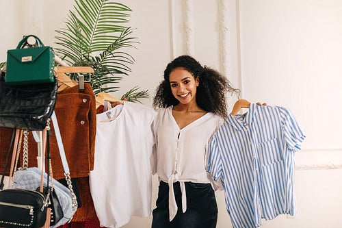 Young stylist choose clothes at rack in studio