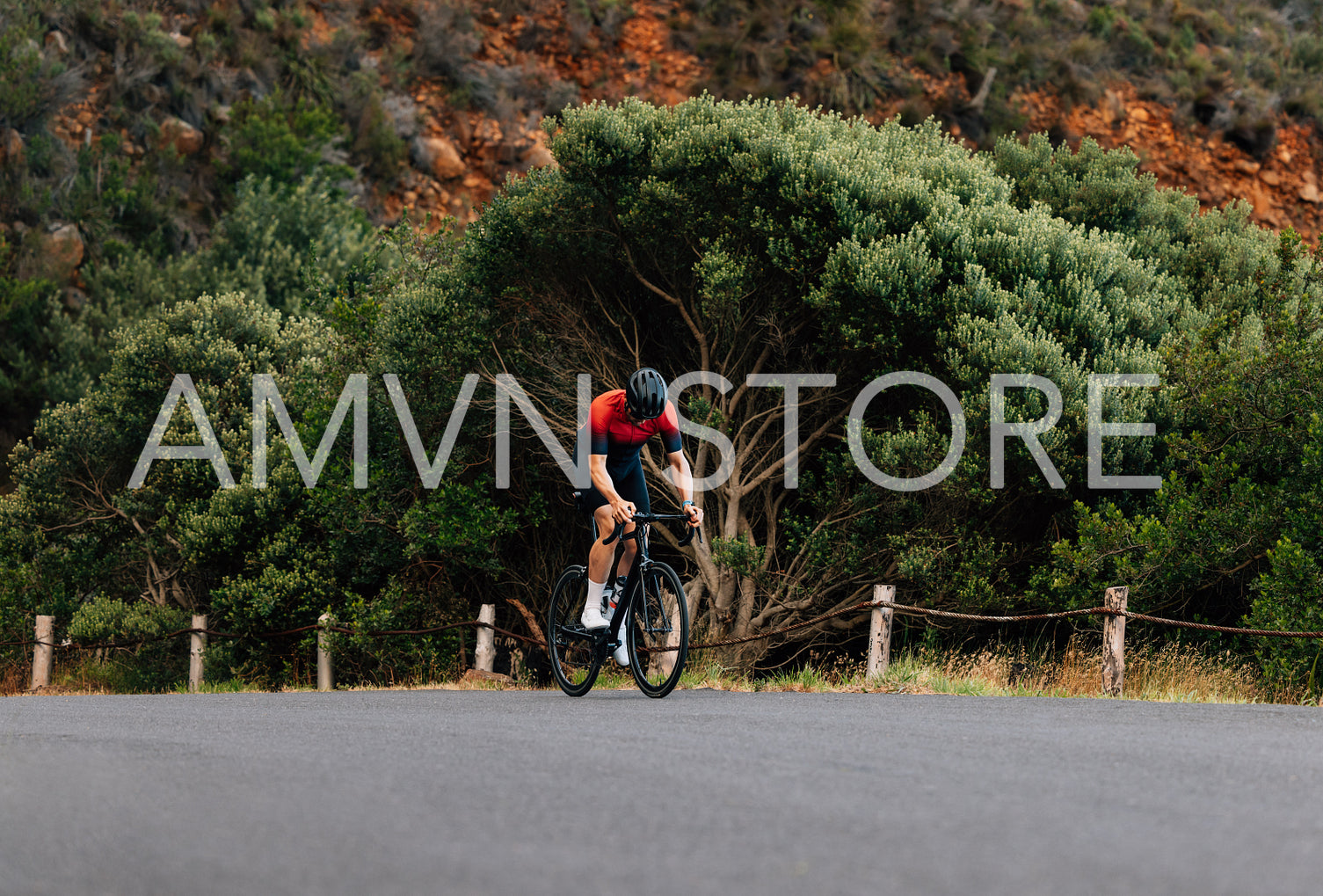 Young man riding a bicycle in wild terrain. Road bike rider practicing outdoors.