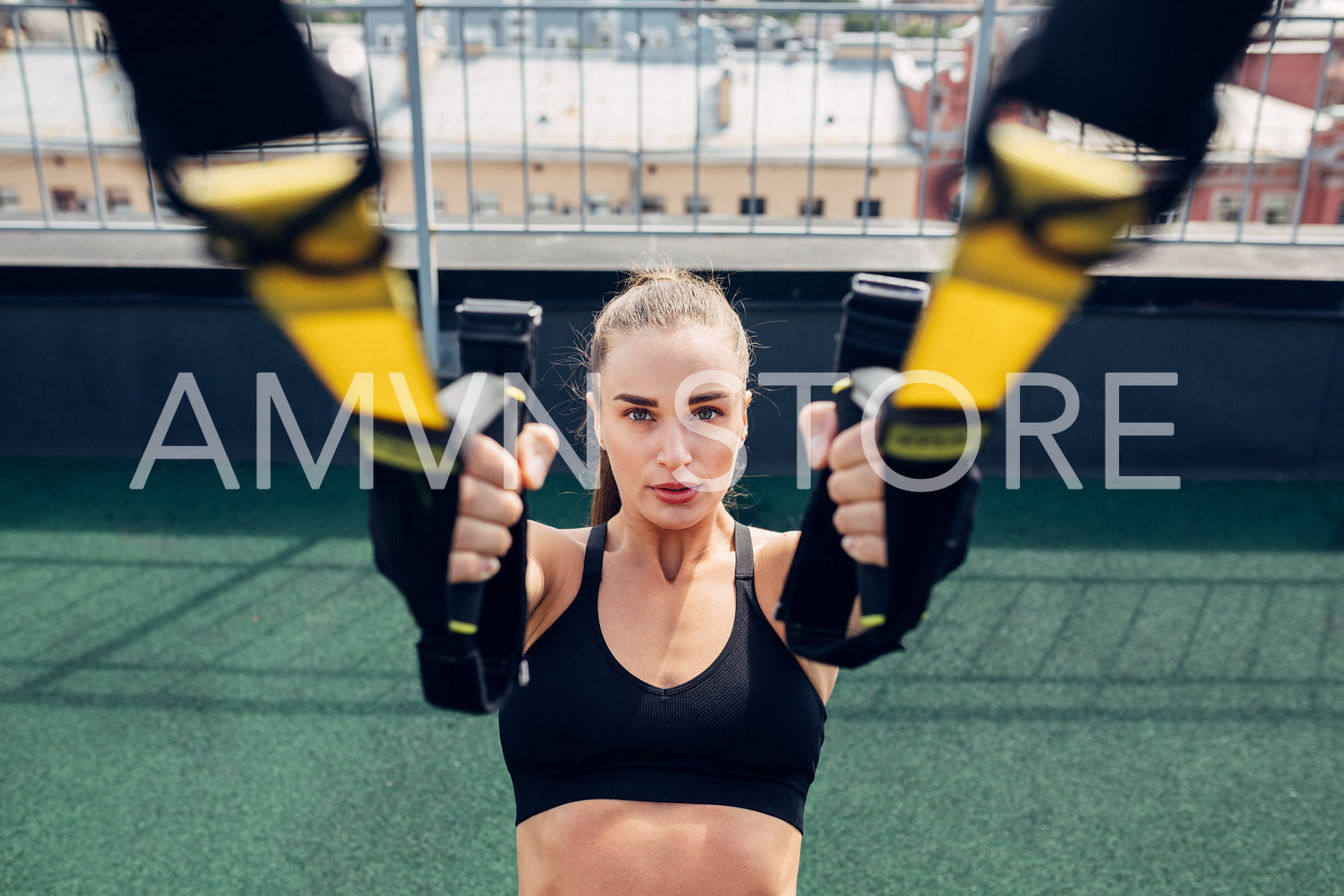 Young woman exercising with suspension ropes outdoors	
