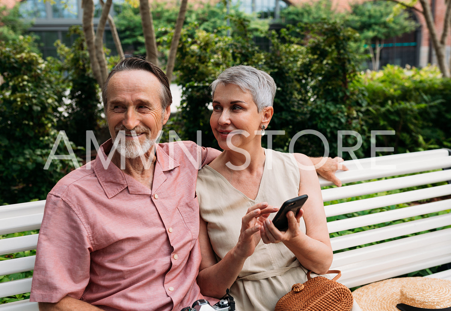 Smiling retired couple sitting on a bench in a park