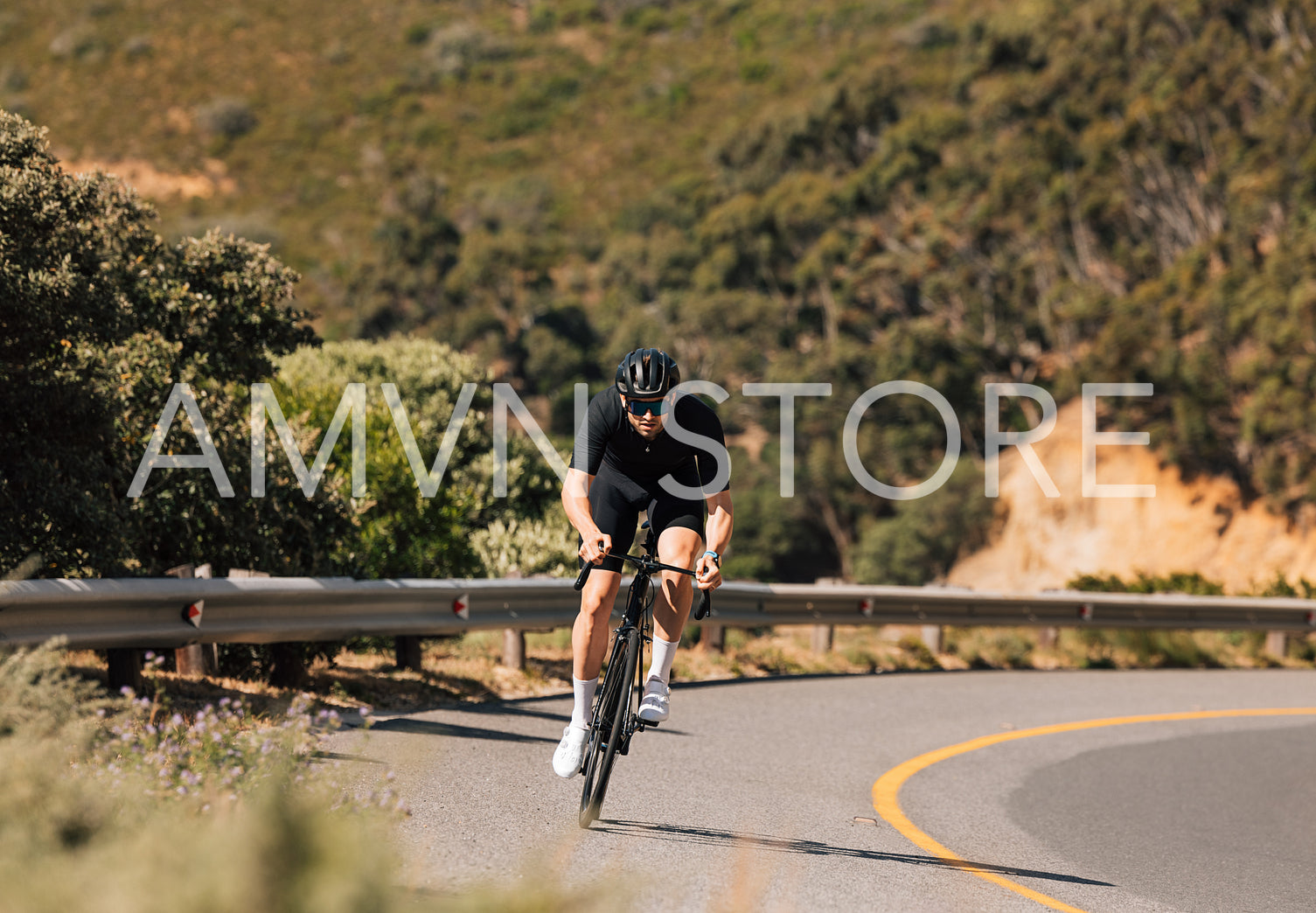 Professional cyclist riding his road bike on a curvy mountain road