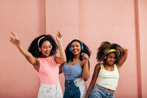 Happy women listening to music and dancing together