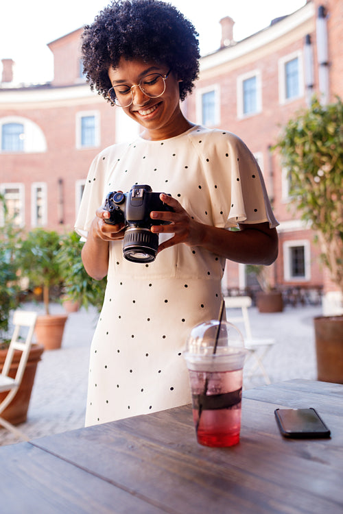 Smiling girl looking on screen of a dslr camera