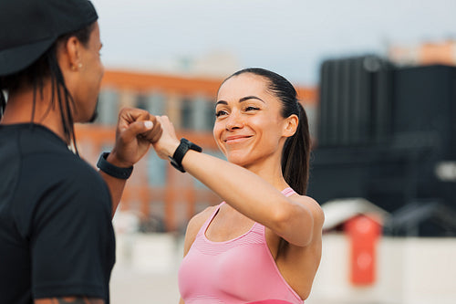 Young athletes giving fist bump after workout on the roof