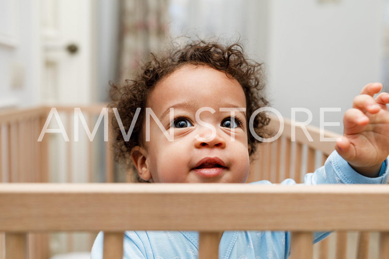 Close up portrait of little baby boy in crib	