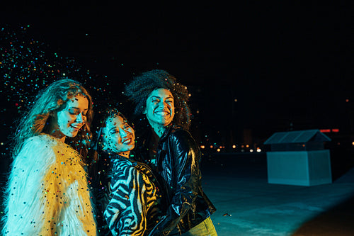 Smiling girls enjoying party at night on the roof